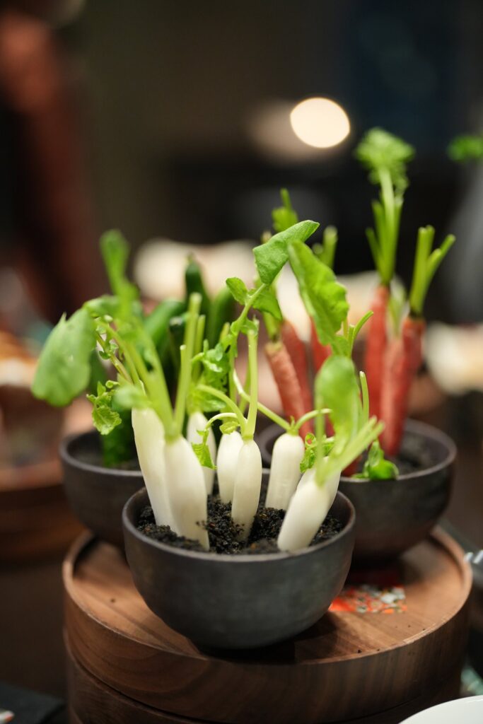 器に盛りつけられた、葉付きの小さな野菜のフィンガーフード